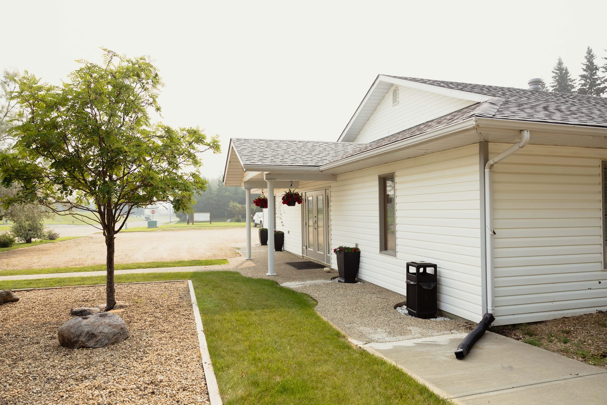 Athabasca Community Chapel on a summer morning, the covered entrance and mountain ash out front